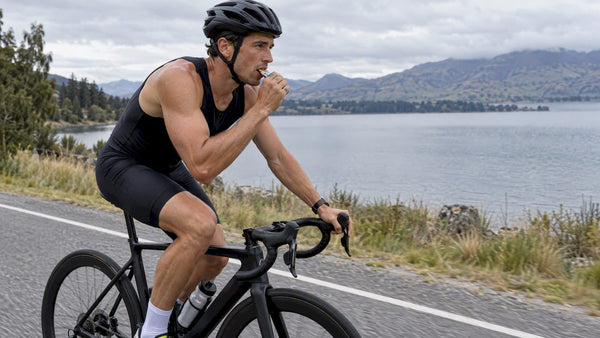 Triathlete taking fuel while cycling