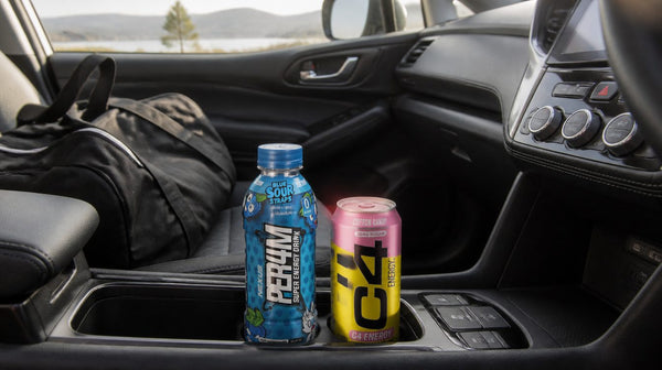 Nexus PER4M RTD bottle and a C4 Carbonated can in a car cup holder next to a gym bag