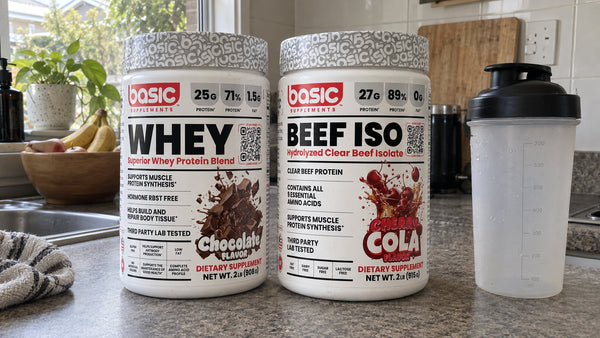Basic Supplements Chocolate Whey and Cherry Cola Beef ISO tubs on a kitchen bench