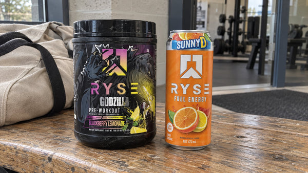 Ryse Godzilla Blackberry Lemonade pre-workout and SunnyD Fuel Energy can on a gym bench