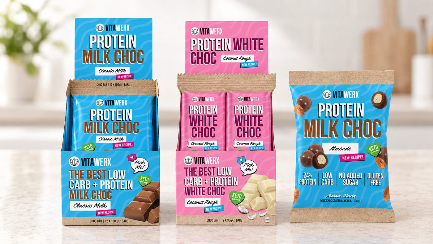 Vitawerx protein chocolate bars, coated almonds and protein nut spread lined up on a bench