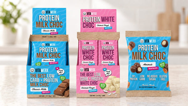 Vitawerx protein chocolate bars, coated almonds and protein nut spread lined up on a bench