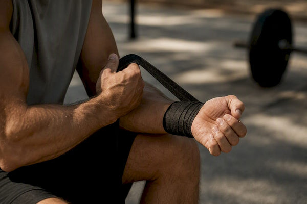 Bodybuilder wrapping wrist with support wrap