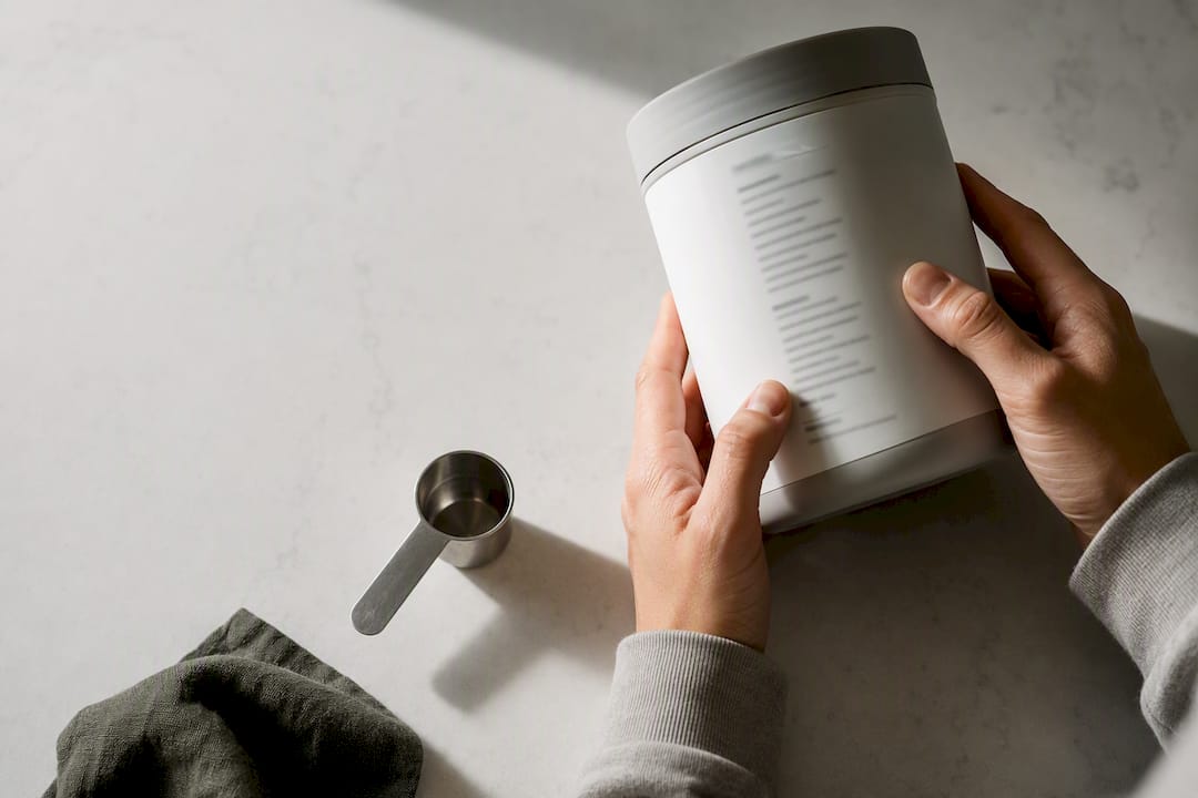 Hands inspecting an anonymous supplement label