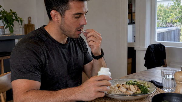 Man taking an enzyme capsule with dinner