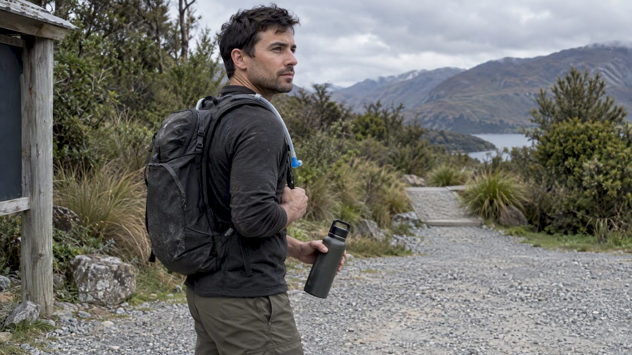 Hiker comparing a pack and water bottle