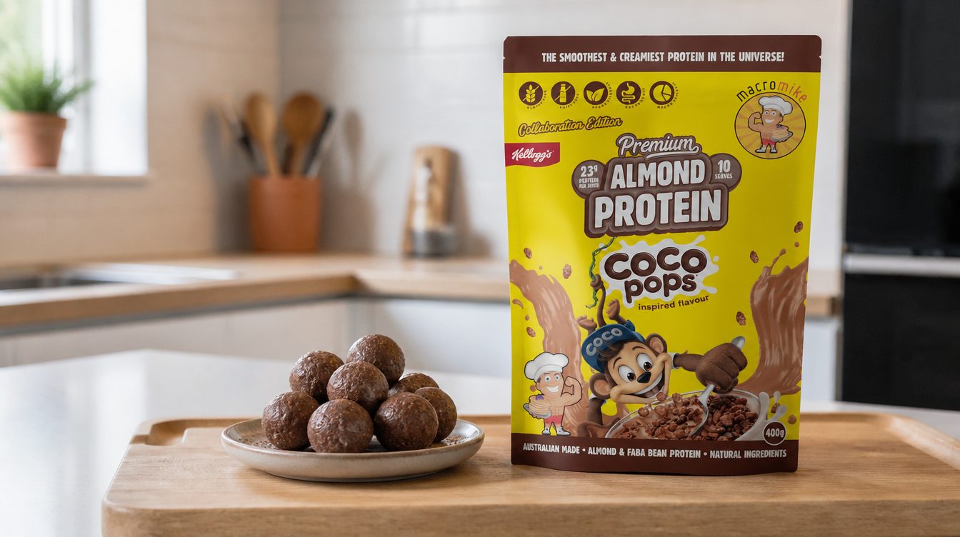 Plate of chocolate Coco Pops protein balls on a wooden board next to a bag of Macro Mike Coco Pops protein