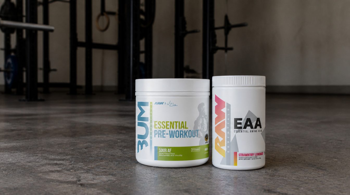 Raw Nutrition Essential pre-workout and Raw EAA tubs on a concrete gym floor with a squat rack behind