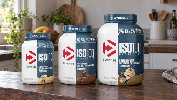 Dymatize ISO100 tubs in Fudge Brownie and Gourmet Chocolate lined up on a bench