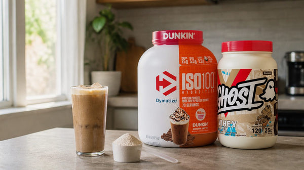 Iced protein coffee in a tall glass beside a scoop and a Dymatize ISO100 Dunkin tub on a home bench