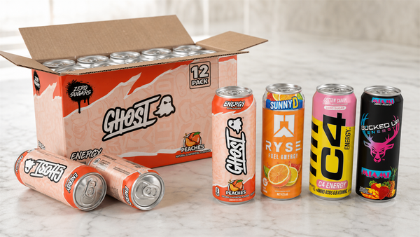 Open Ghost Energy Peach 12-can case with Ryse Fuel, C4 and Bucked Up energy drink cans lined up in front
