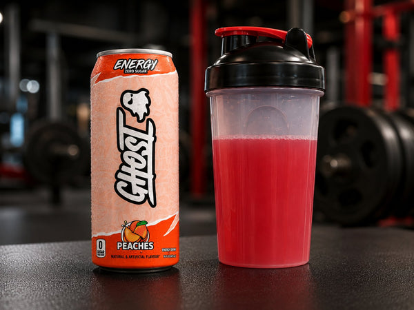 Ghost Energy can next to a shaker of pre-workout mix in a gym, comparing energy drink and pre-workout before training