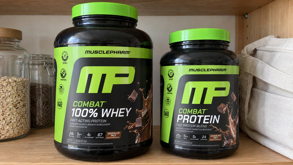 MusclePharm Combat 100% Whey and Combat Protein chocolate tubs in a home setting