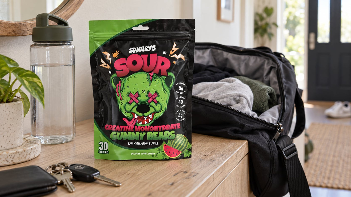Swoleys Sour Watermelon Creatine Gummy Bears beside an overnight bag and water bottle.