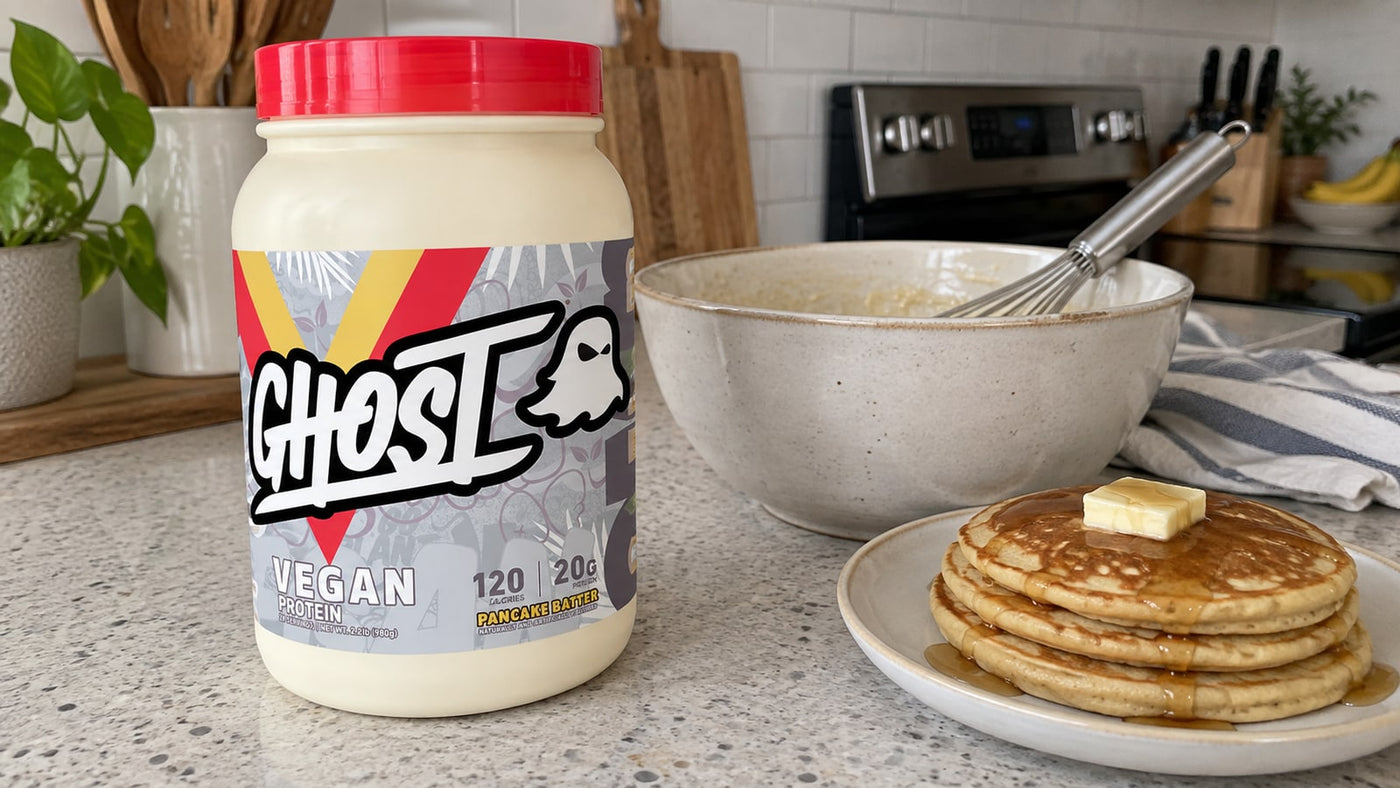 GHOST Vegan Pancake Batter protein beside a mixing bowl and pancakes.