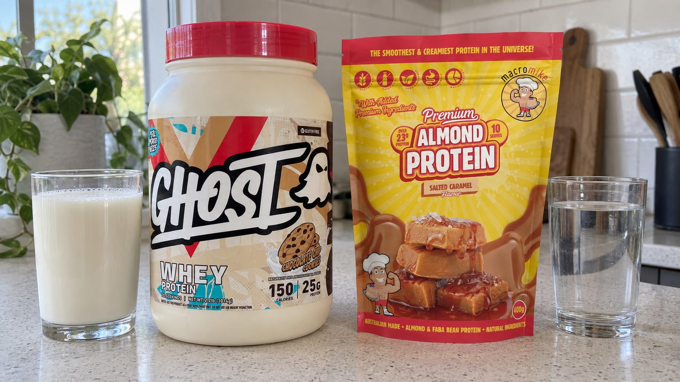GHOST Whey and Macro Mike Almond Protein Salted Caramel beside milk and water.