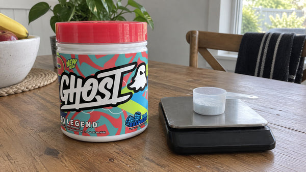 GHOST Legend Blue Raspberry beside a small powder scoop and kitchen scale.