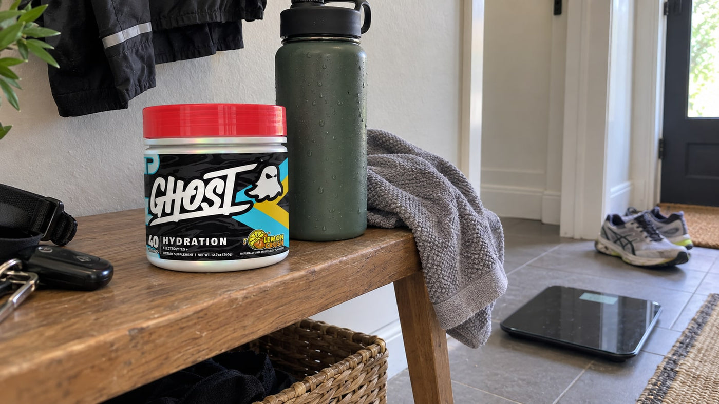 GHOST Hydration Lemon Crush beside a running bottle, towel and bathroom scale.