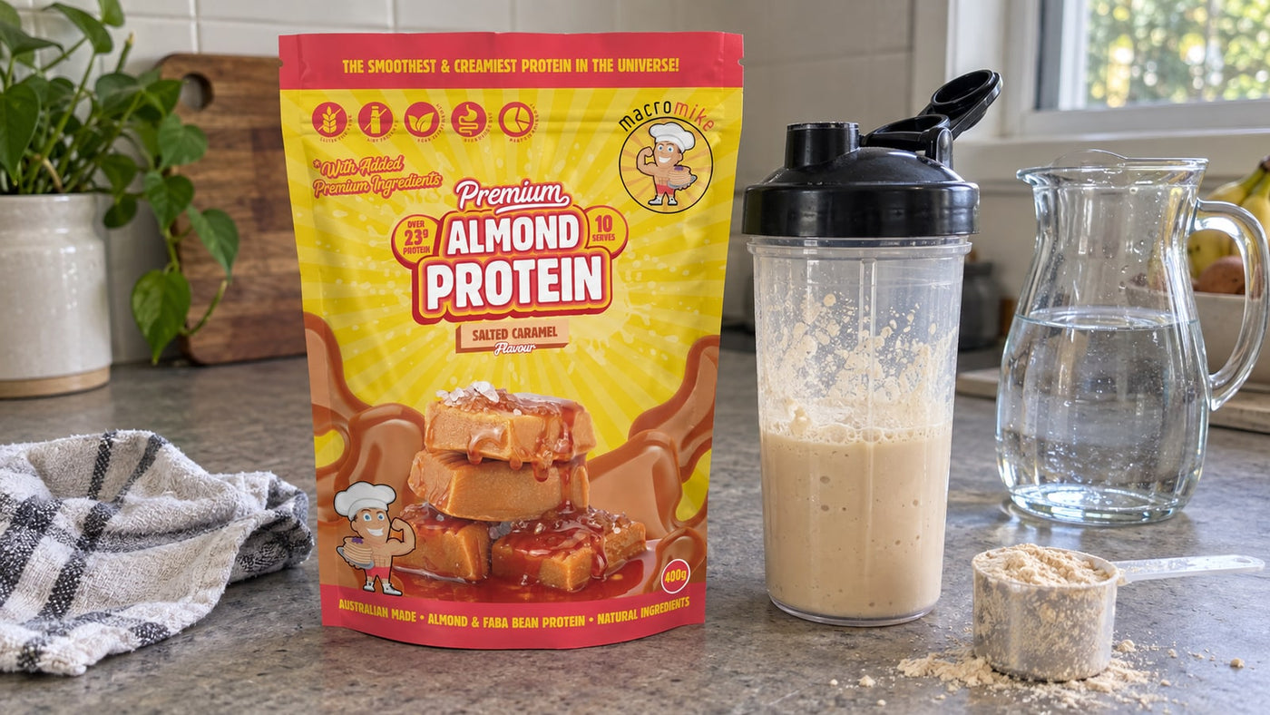 Macro Mike Almond Protein Salted Caramel beside a shake, water jug and scoop.